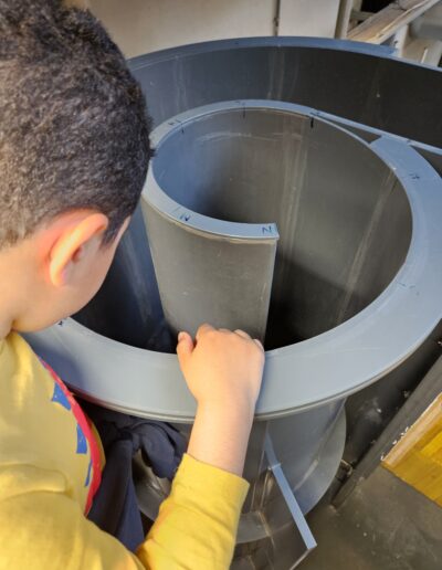 Un enfant qui regarde une pièce en plastique cylindrique