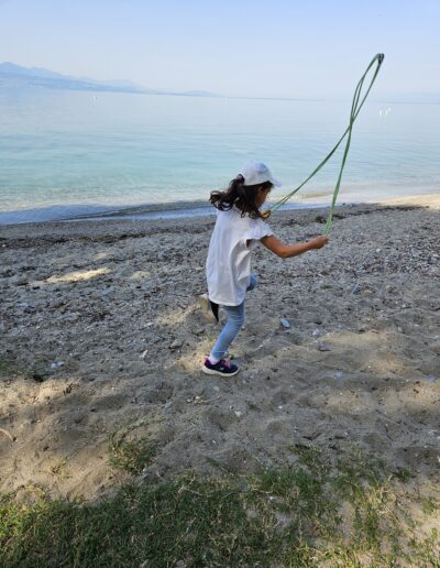 Une fillette qui fait de la corde à sauter sur une plage du lac Léman.